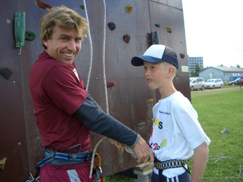 2.15c_PALI_CIMG1252 Runar sikrer en ung deltaker p� barnefestivalen for klatring i klatreveggen